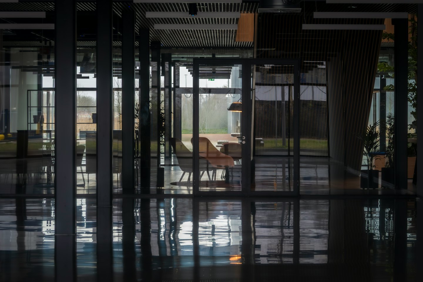 Modern office with dark beams and glass walls.